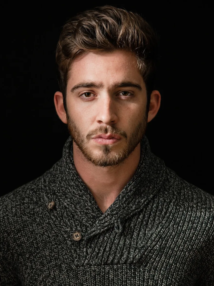 Studio portrait against a dark backdrop, in a textured knit.