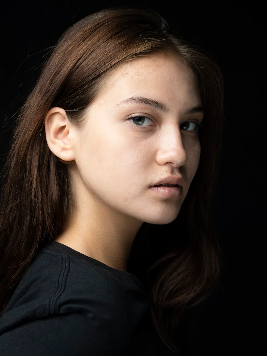 Studio portrait against a dark backdrop, looking directly at the camera.
